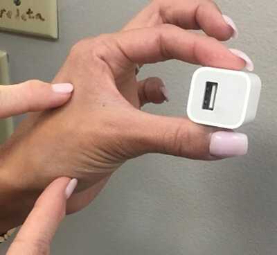 close-up of a person's hand grasping a USB adaptor