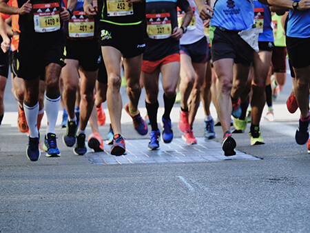 photo showing the legs and feet of multiple marathon runners in action