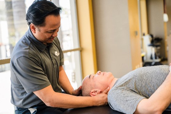 A male physical therapist working with a male patient. 